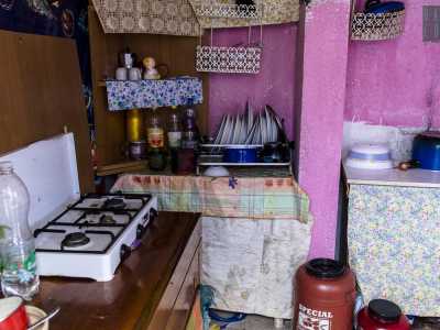 La piccola cucina dipinta di rosa con piatti, pentole e un fornellino per cucinare (foto di Gennaro Gargiulo)
